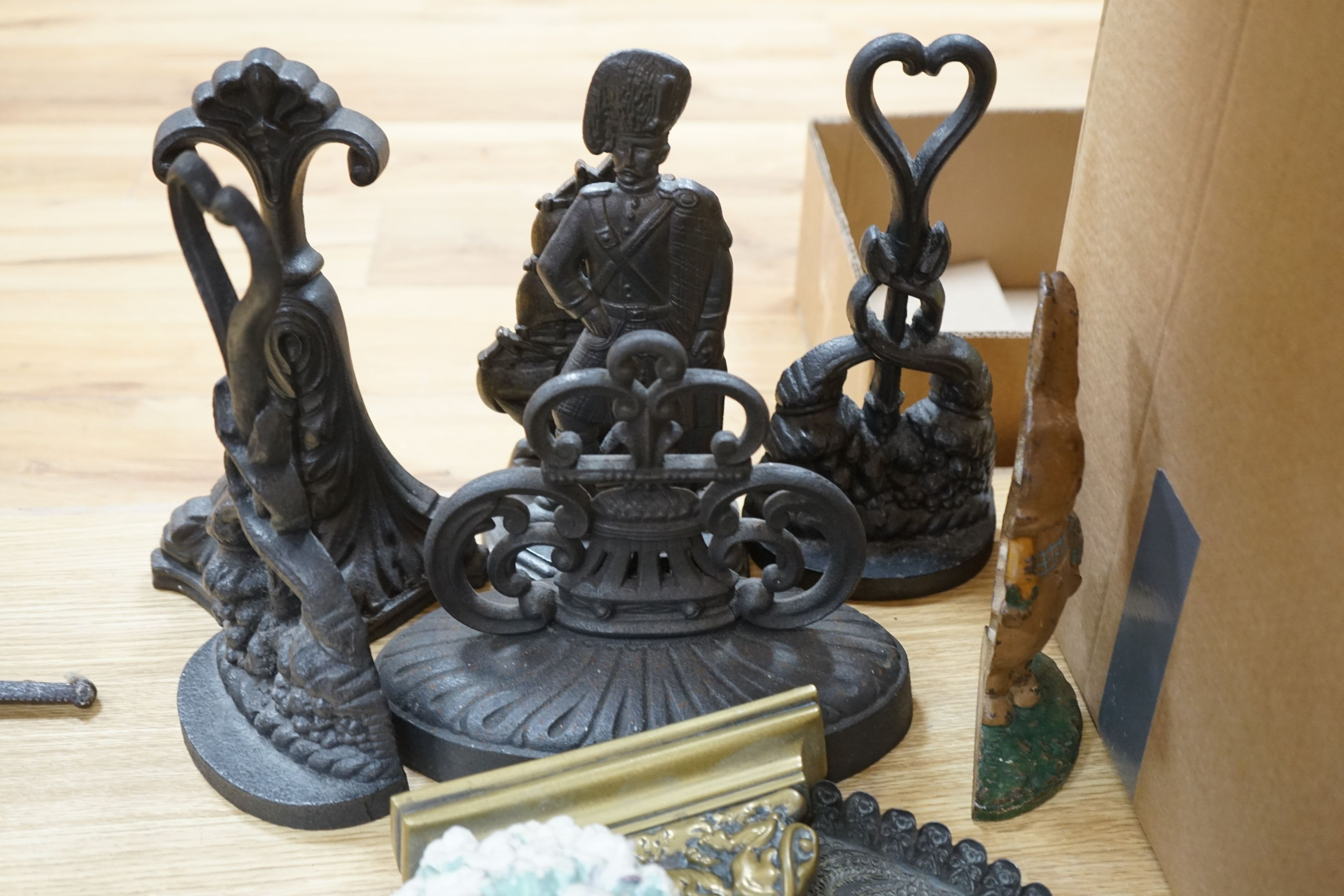 Eight cast iron door stops, a brass lion, a tray, two panels and two floral plaster models, (13)
